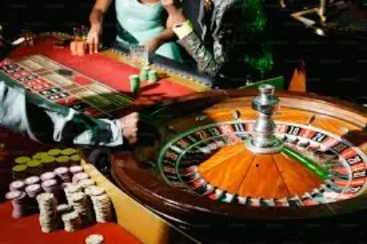 Players betting at a roulette table in a busy casino – play and win with 1betvegas APK on APKADD